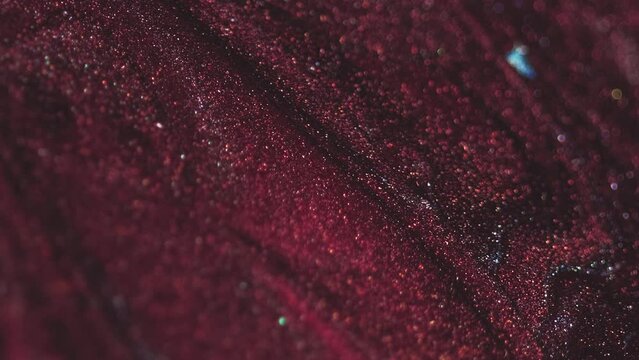 Shimmering fluid background. Shiny liquid flow. Lacquer texture. Trendy burgundy color smooth glitter polish wave spreading in abstract beautiful art.