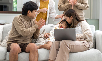 Father and mother with asian kid girl learn on laptop computer reviewing lesson study with online education e-learning.student look for educational knowledge in homeschool at home.Education