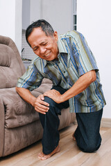 Fototapeta premium Unhappy elderly senior man suffering from knee ache at home