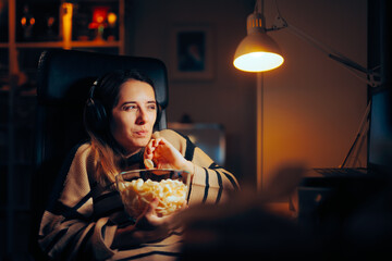 Funny Woman Eating Chips Watching a Show on her Laptop. Girl passing her leisure time at home...