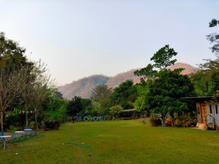 Fototapeta na wymiar Fresh mountain and greenery grass with lots of trees