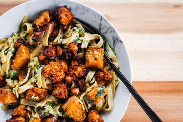 plant-based fettuccine pasta with spinach pumpkin and tofu chunks
