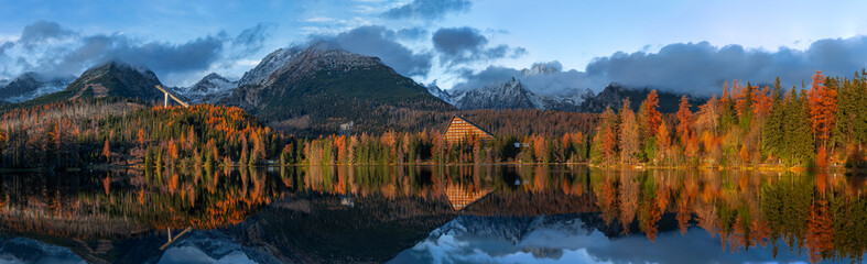 Strbske Lake, Slovakia - Panoramic view of reflecting amazing Strbske Lake (Strbske Pleso) on a sunny autumn afternoon with High Tatras and Tatras Tower at background with Warm autumn colors