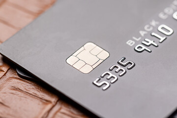 Closeup of black credit card on leather notepad