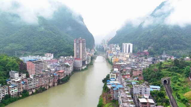 panoramic aerial of Yunnan city, Yanjin county from river, apartment buildings and chinese homes