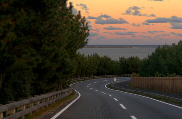 Winding shoreline road at sunset