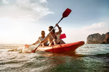 Fotobehang Happy couple walks by sea kayak or canoe at tropical bay © cppzone