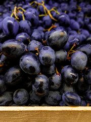 Dark juicy grapes in a wooden box