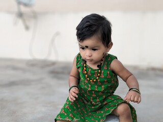 Baby girl expression portrait in green skirt