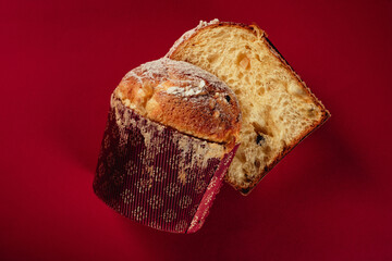 Traditional Italian Christmas cake Panettone. Artisan Pastry on red background. Close up pastry texture.