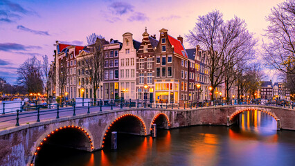 Naklejka premium Amsterdam Netherlands canals with lights during evening in December during winter in the Netherlands