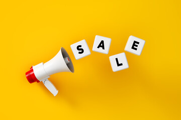 The word Sale written on white blocks with a megaphone over yellow background.