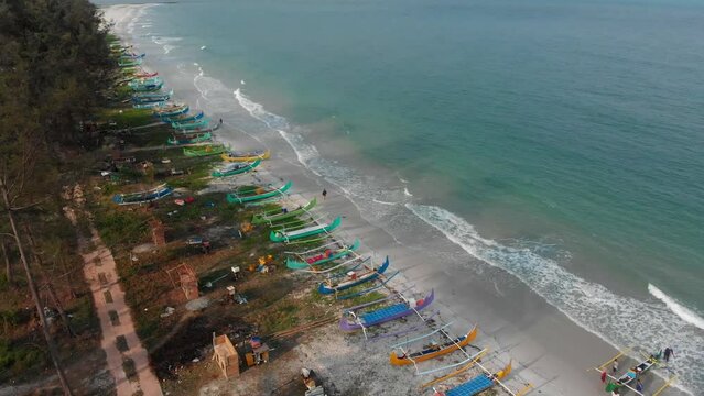 Wide shot of Serdang beach with fishing boats on shore at Belitung, aerial
