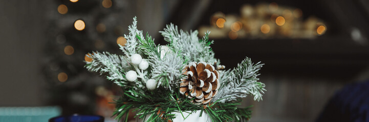 Christmas arrangement with candles. Hands close-up. decorative ornaments. Christmas decor with own hands. The new year celebration.spruce branches on a wooden table.