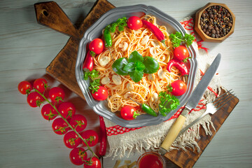 Pasta, spaghetti in a plate with seasonings and vegetables. Hot, natural and tasty dish.