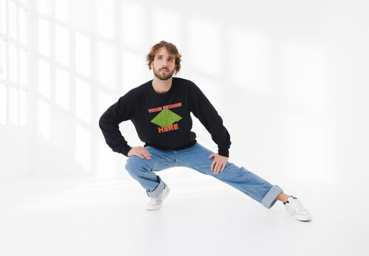 Mockup of man wearing customizable sweatshirt, crouching with leg out