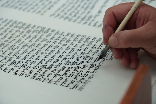 hand writing of a Jewish Torah scroll with a quill or feather according to ancient Jewish tradition.