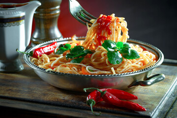 Boiled pasta with ketchup and vegetables on the kitchen table.