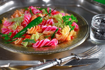 Pasta, spaghetti in a plate with seasonings and vegetables. Hot, natural and tasty dish.