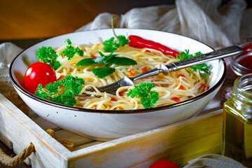 Boiled pasta with ketchup and vegetables on the kitchen table.