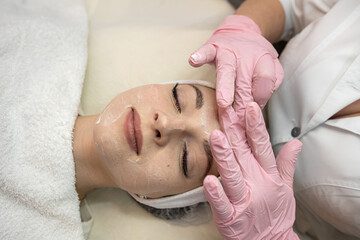 Obraz na płótnie Canvas young caucasian woman getting facial spa massage at spa salon