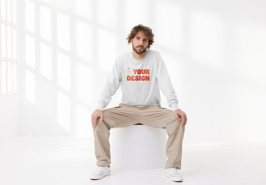 Mockup of man wearing customizable sweatshirt, sitting on plinth