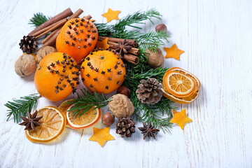 Christmas background. natural decor of dried orange slices, nuts, spices, cones, fresh oranges decorated cloves on wooden table close up. Christmas, New Year holidays. festive winter season