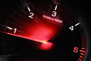 Motion blur of a car instrument panel dashboard odometer with red illuminated display.Car speedometer. High speed car speedometer and motion blur at night.
