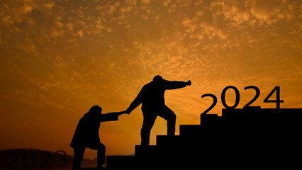 New year concept. Silhouette Man and Woman holding hands walking up the stairs celebrating year...
