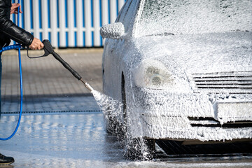 Self service high pressure car wash. Vehicle covered with foam
