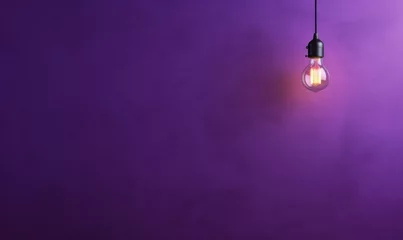 Foto op Canvas arrière plan violet uni avec une ampoule allumée qui pend © Fox_Dsign