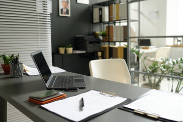 Modern workplace of consultant with laptop and documents in office