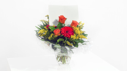 Fresh bouquet of flowers with gift card on white background.