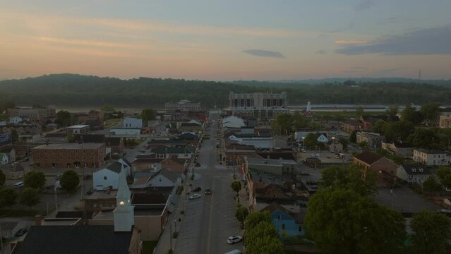 Aerial of main street in Lawrenceburg, Indiana with a slow push down the street and towards the Ohio River and a beautiful morning sky at sunrise.