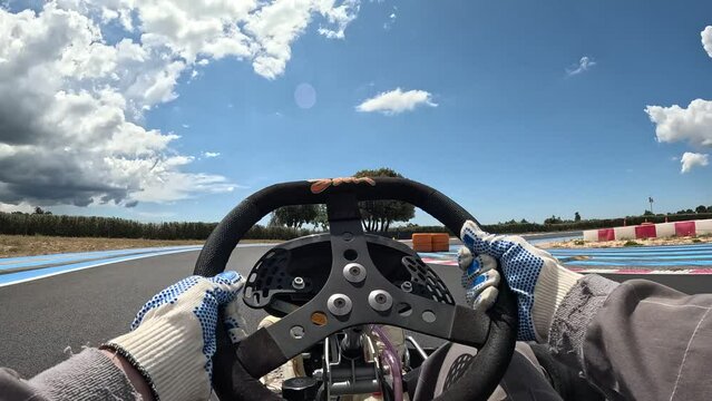 Driver's Hands On Steering Wheel Of 2-stroke Go-kart, Driving On Racing Track. POV