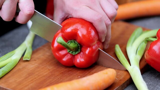 Fresh peppers cut up by cook on wooden chopping board
