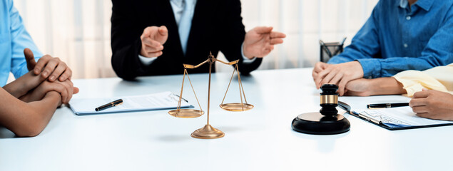 Focused gavel hammer and balance scale of justice on blurred background of lawyer acting as...