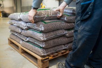 Bags with wood pellets, pellet fuels manufactured in wood pellet line. Reusing wooden industrial...