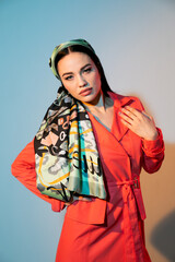 Fashionable woman in headscarf posing in studio