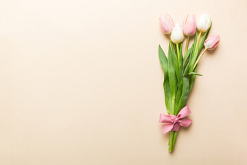 Bouquet of pink tulips on colored table background . Top view with copy space. Waiting for spring. Happy Easter card. Flat lay