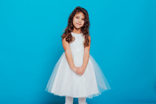 Girl in white elegant dress on a blue background Holiday