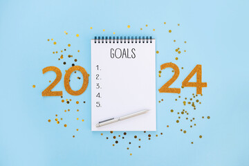 New Year goals List 2024 with notebook written in handwriting about plan listing of new year goals,...