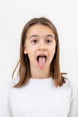 Portrait of a teenage girl showing her tongue isolated on a white background.