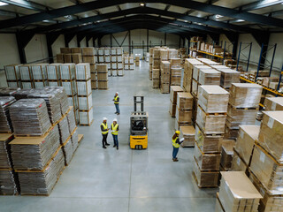 Top view of warehouse workers in warehouse. Team of warehouse workers preparing products for...