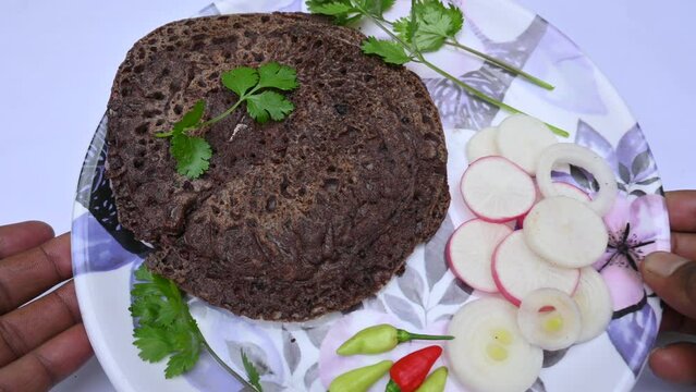 Eleusine coracana or finger millet chapati. Its other names Ragi and madua in India and Kodo in Nepal. Indian Traditional Ragi roti or flat bread. Madua roti or flat bread.  Shot on white background.
