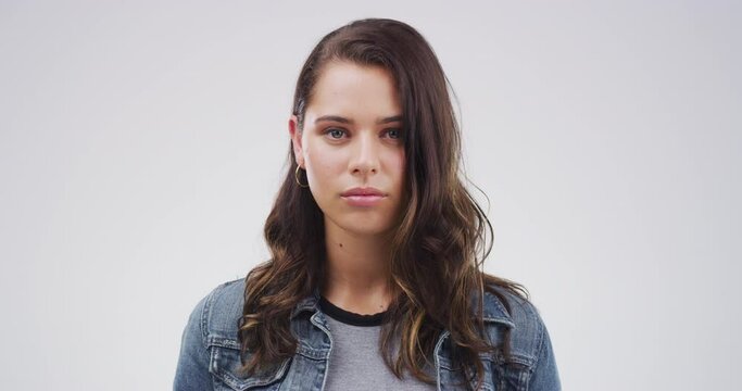 Serious woman, face and brunette with blank stare standing isolated against a studio background. Portrait of attractive caucasian female person or casual model looking with no expression on mockup