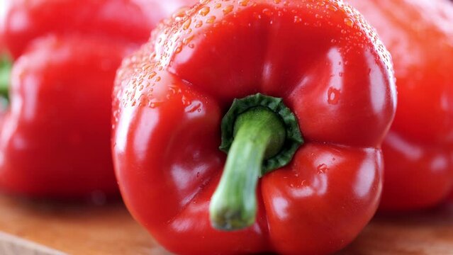 Fresh red pepper on wooden chopping board, extreme close-up pan