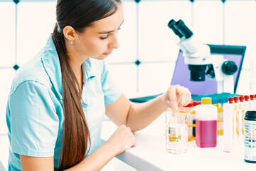 young woman in the laboratory measures the acidity of drinking water using a rapid test