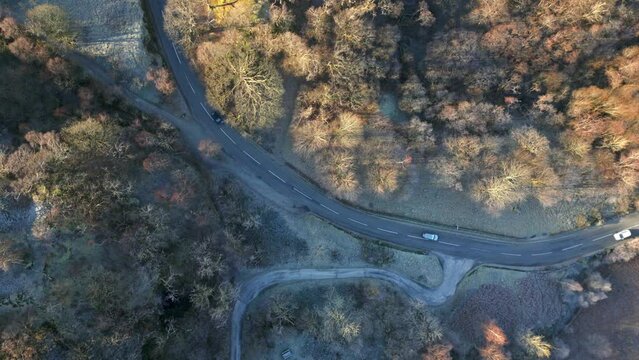 Cars on forest road downward view on frosty autumn morning. Borrowdale, English Lake District National Park, Cumbria, UK.