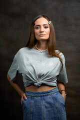 Young European woman with brown hair wearing a denim skirt and T-shirt